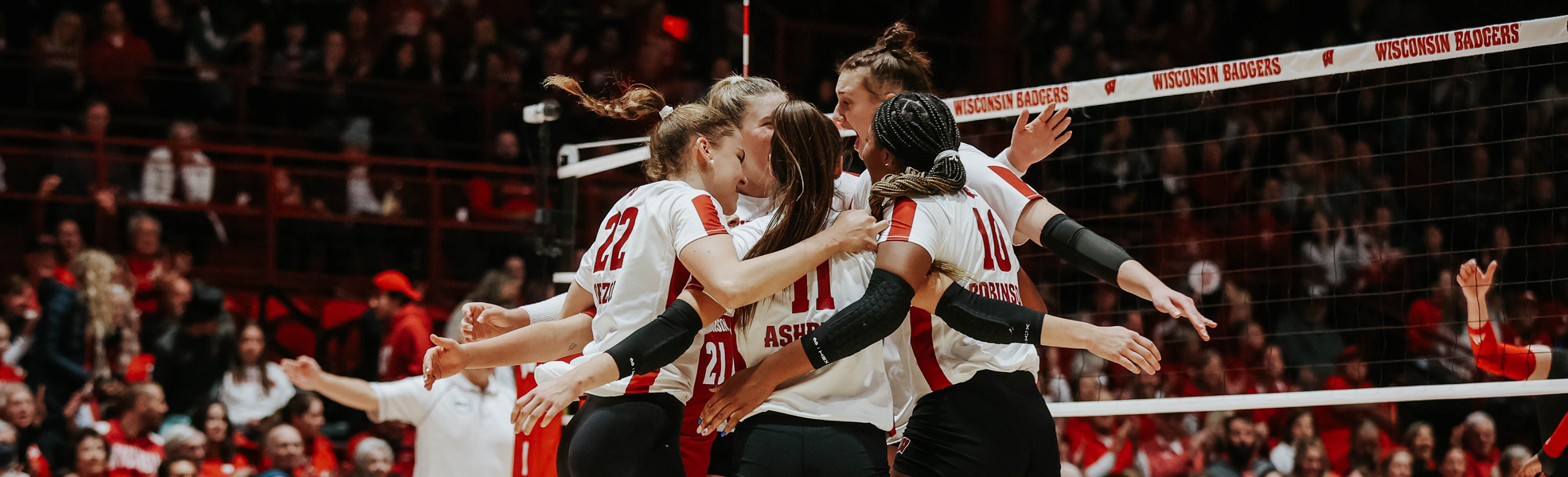 Photo of the UW-Madison Volley Ball Team at the field house, celebrating.
